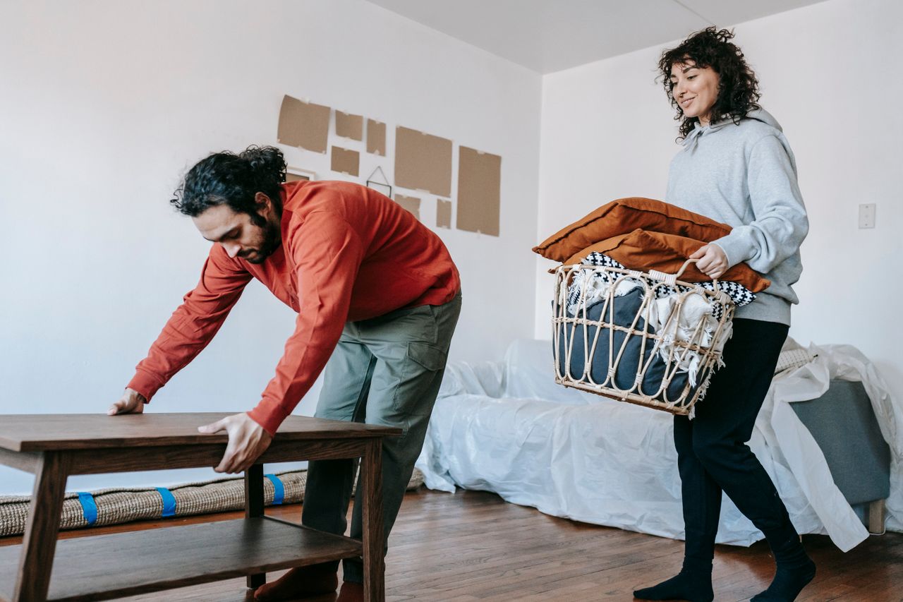 heros-img A couple organizing furniture and packing in a modern apartment for relocation.